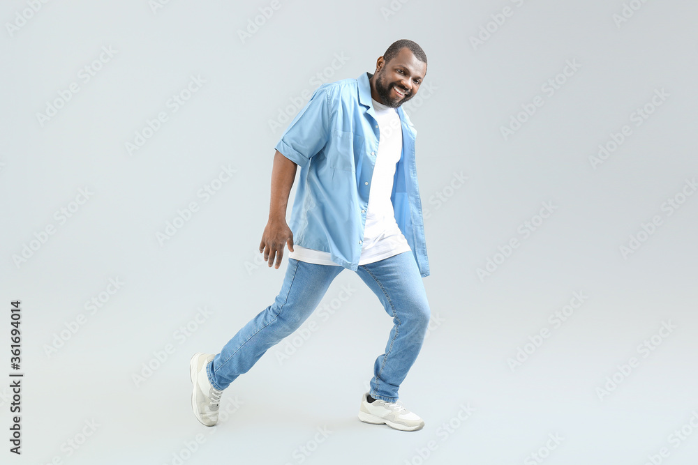 Male African-American hip-hop dancer on light background Male African-American hip-hop dancer on light background