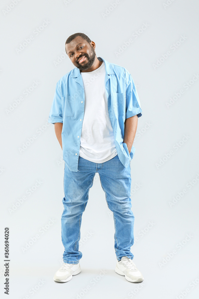 Fototapeta premium Male African-American hip-hop dancer on light background