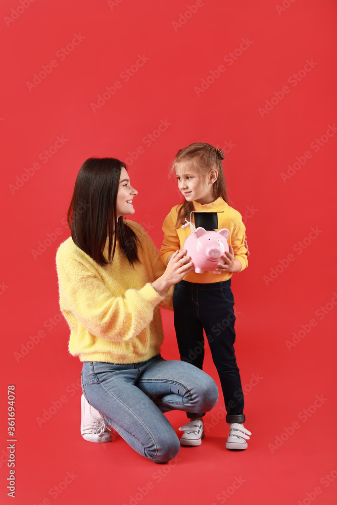Little girl and her mother with savings for education on color background Little girl and her mother with savings for education on color background