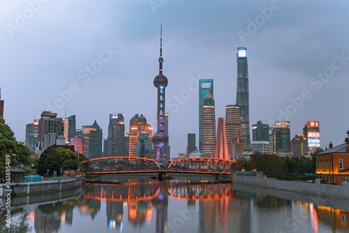 Night view of Waibaidu Bridge and Lujiazui, the skyline and landmark in Shanghai, China, with reflection in front.