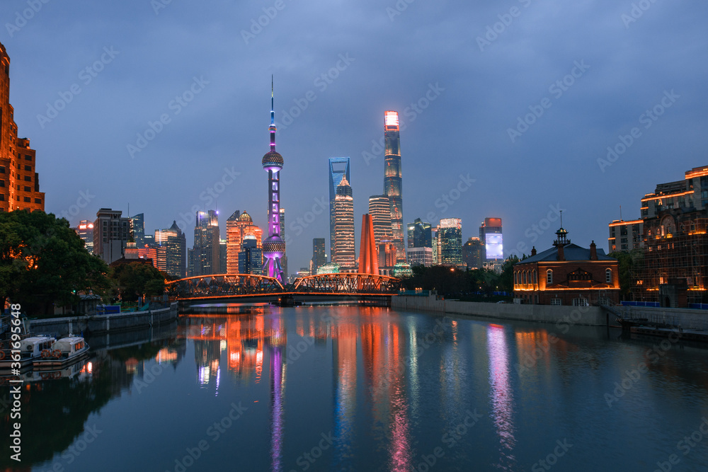 Night view of Waibaidu Bridge and Lujiazui, the skyline and landmark in Shanghai, China, with reflection in front.