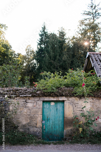 Blue garden door in stone wall in French village