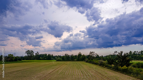 Drone view of an agriculture landscape with dramatic cloudscape at a stormy day in summer.