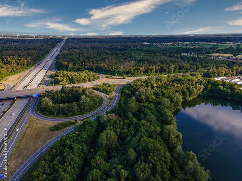 The highway intersection of the highway 5 between Frankfurt and Darmstadt in Germany with the lake Oberwaldsee at a cloudy and windy day in summer.