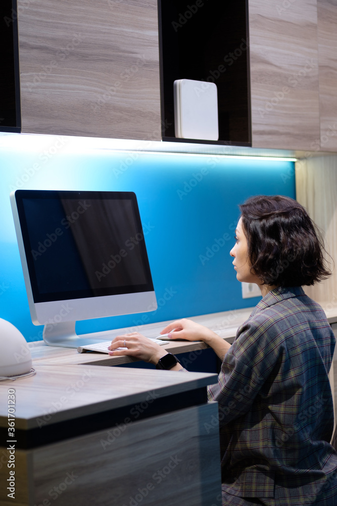 Young hardworking smiling Caucasian businesswoman sitting in her office and using computer. Corporate business concept,.