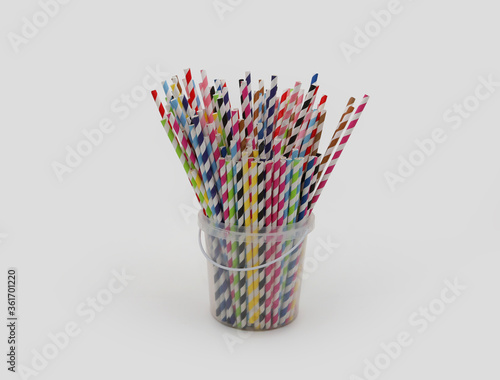 Drinking colorful paper straws for cocktails in a plastic bucket on white background.