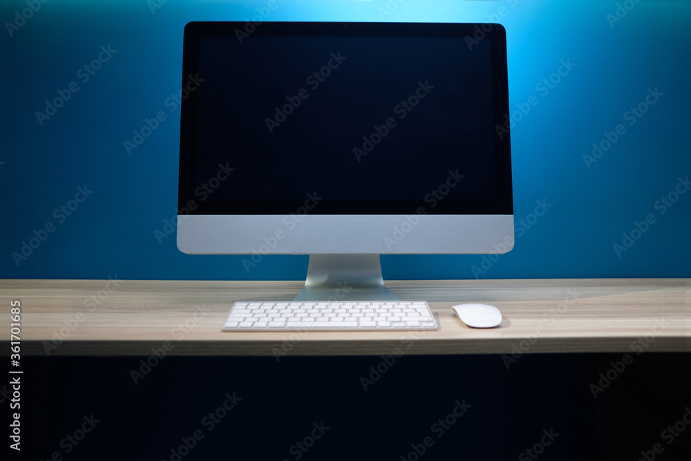 Office workplace with computer./ Modern creative workspace on blue wall.. Office workplace with computer./ Modern creative workspace on blue wall..