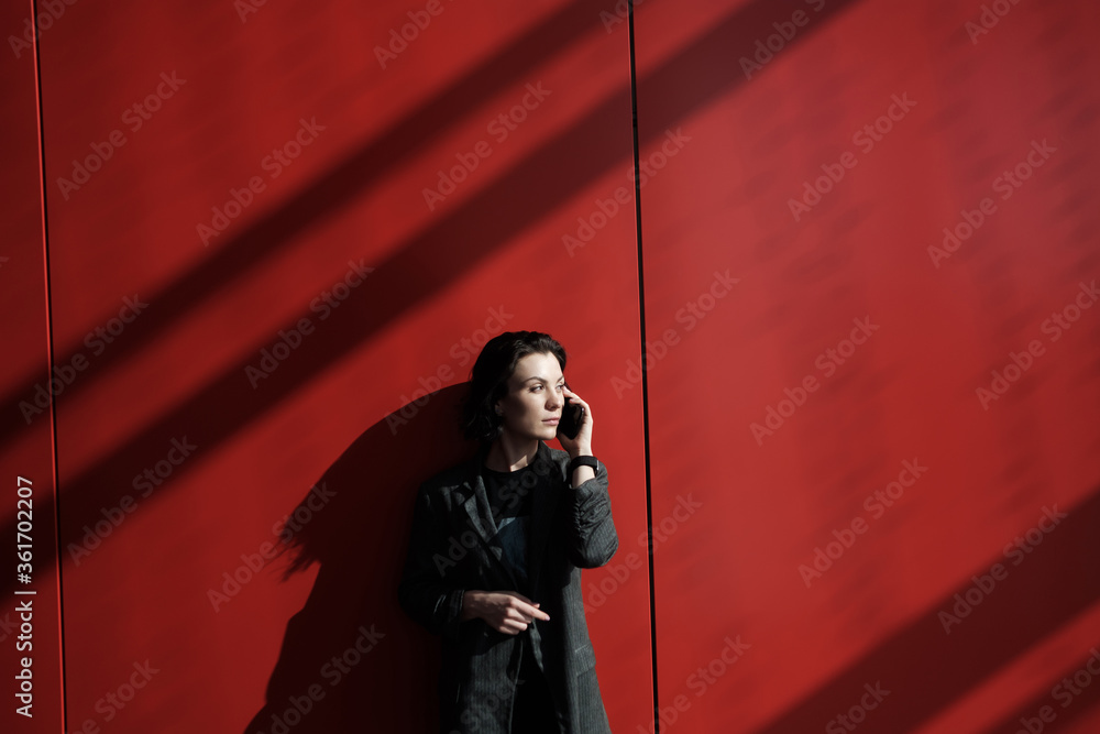 Photo business woman talking smartphone and holding documents in hands. Open space loft office. Panoramic windows background. Horizontal mockup. Film effect. Photo business woman talking smartphone and holding documents in hands. Open space loft office. Panoramic windows background. Horizontal mockup. Film effect.