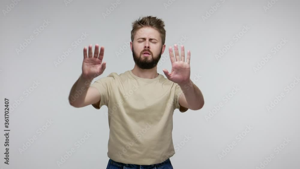 Blind bearded man stumbled upon obstacle touching invisible wall, walking with his eyes closed in darkness, having vision problems, feeling confused disoriented, lost way. indoor studio shot isolated Blind bearded man stumbled upon obstacle touching invisible wall, walking with his eyes closed in darkness, having vision problems, feeling confused disoriented, lost way. indoor studio shot isolated