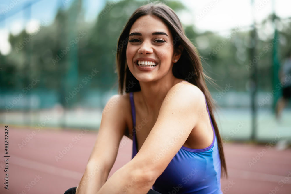 Young sporty woman resting on running track. Beautiful woman in sportswear Young sporty woman resting on running track. Beautiful woman in sportswear