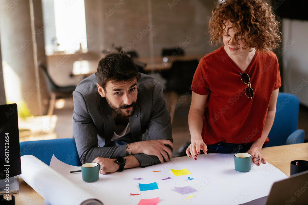 Colleagues working on the project. Businesswoman and businessman discussing work in the office. Colleagues working on the project. Businesswoman and businessman discussing work in the office.