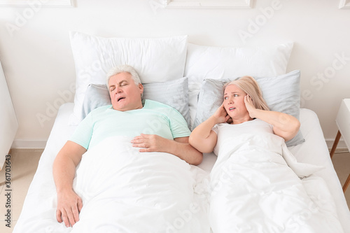 Mature irritated woman in b...