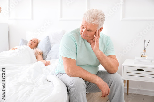 Mature irritated man in bed...