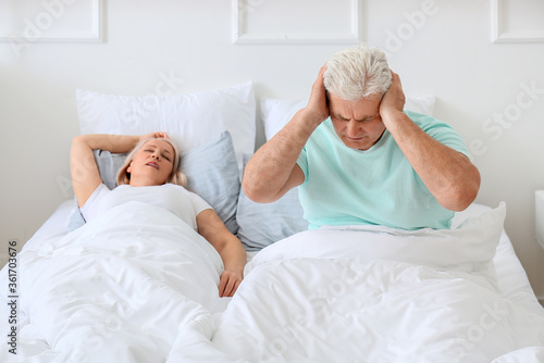 Mature irritated man in bed...