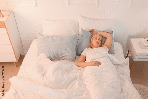Mature woman snoring while sleeping in bed. Apnea problem