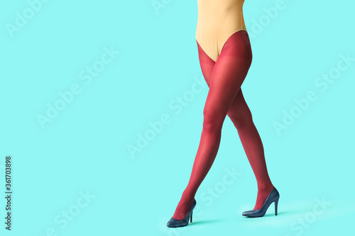 Beautiful young woman in tights on color background