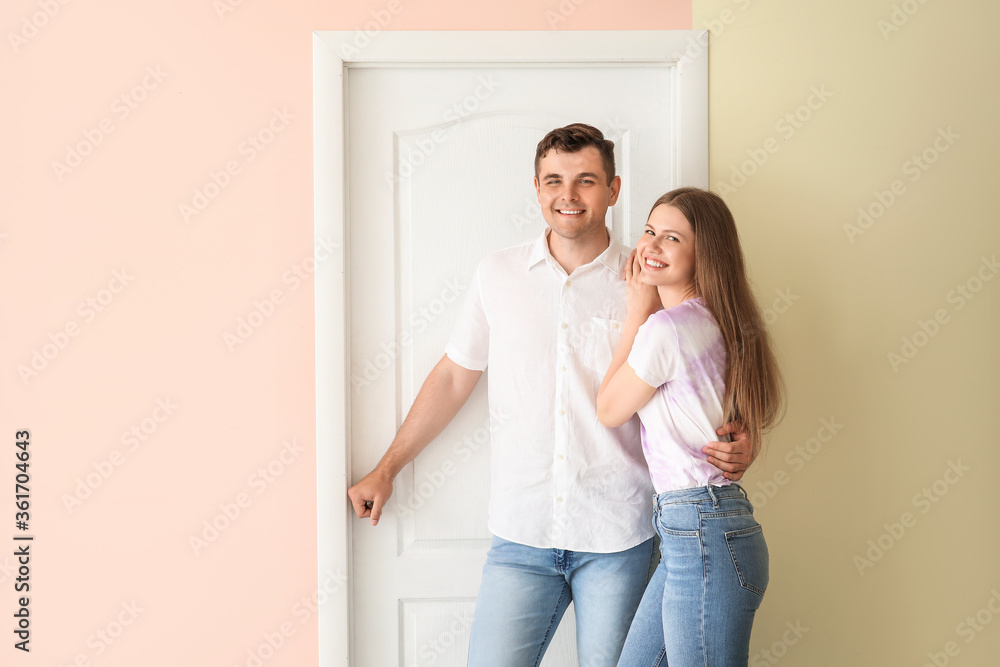 Happy couple in front of door at their new home Happy couple in front of door at their new home