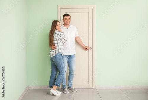 Happy couple in front of do...