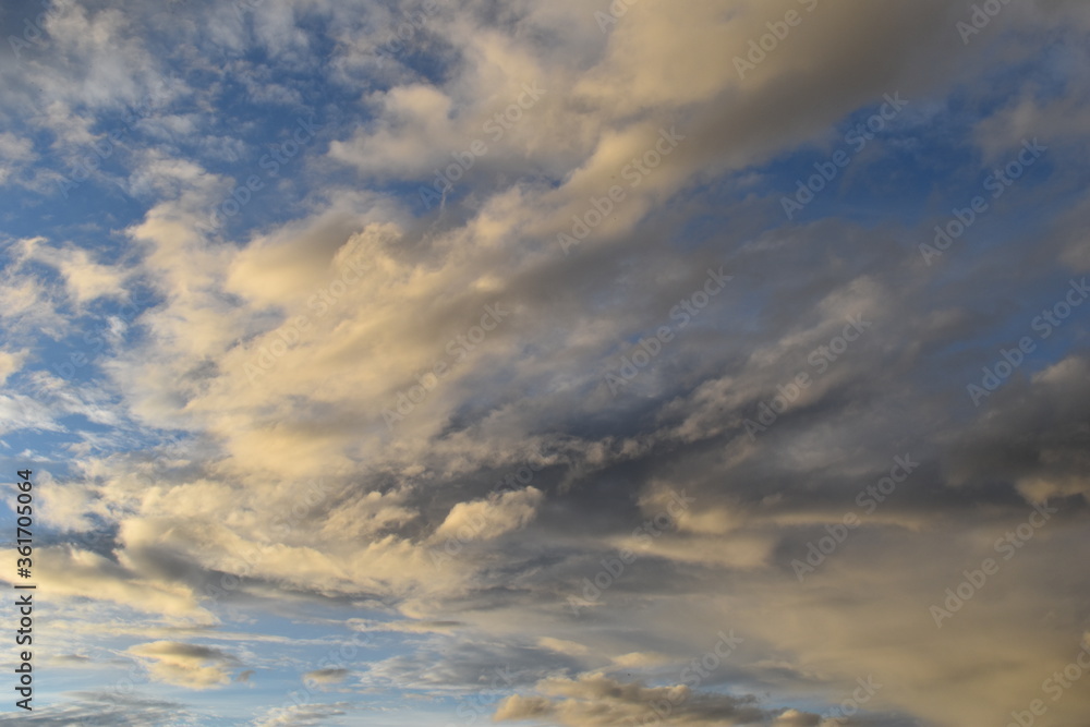 Multi colored photo of clouds at dusk, blue sky with white and gray clouds. 