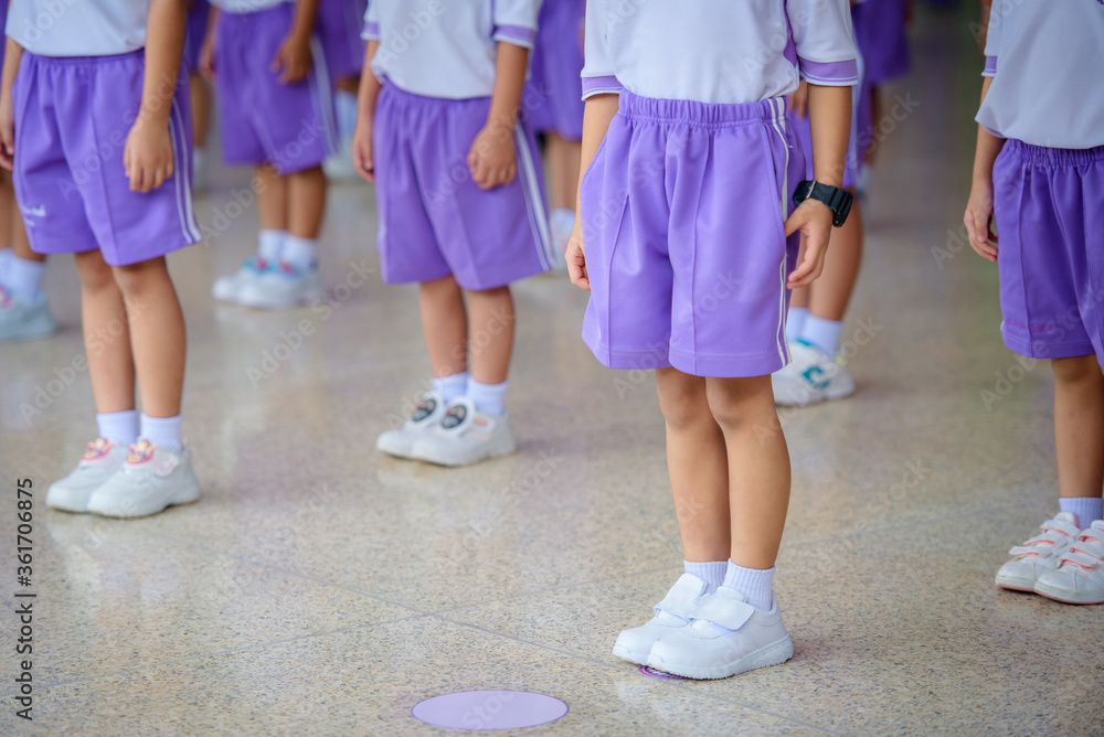 Picture of school children standing in line in kindergarten and standing spaced to prevent disease The Covid-19 Virus Stand in line and social distancing, stand in line, prepare to attend school