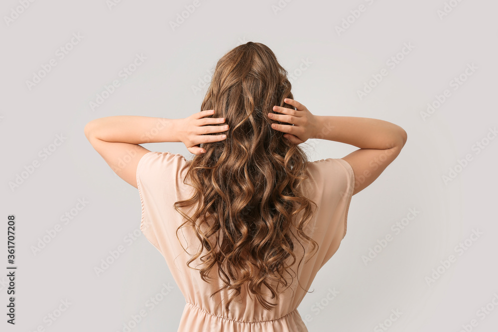 Beautiful young woman with stylish hairdo on grey background, back view Beautiful young woman with stylish hairdo on grey background, back view