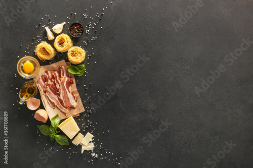 Fotografi Ingredients for tasty pasta carbonara on dark background