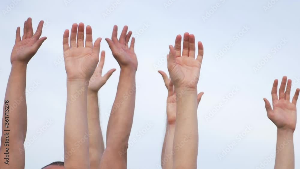 Teamwork. A group of people against the sky raises their hands up. The concept of voluntary voting, expression of consent, support for democracy. Teamwork. A group of people against the sky raises their hands up. The concept of voluntary voting, expression of consent, support for democracy.
