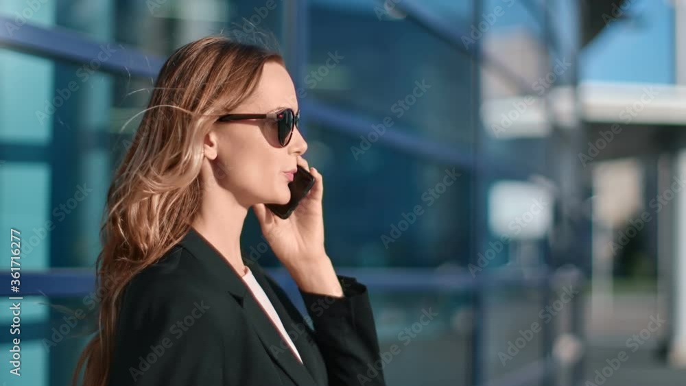 Stylish business woman talking smartphone at office building exterior. 4k Dragon RED camera Stylish business woman talking smartphone at office building exterior. 4k Dragon RED camera