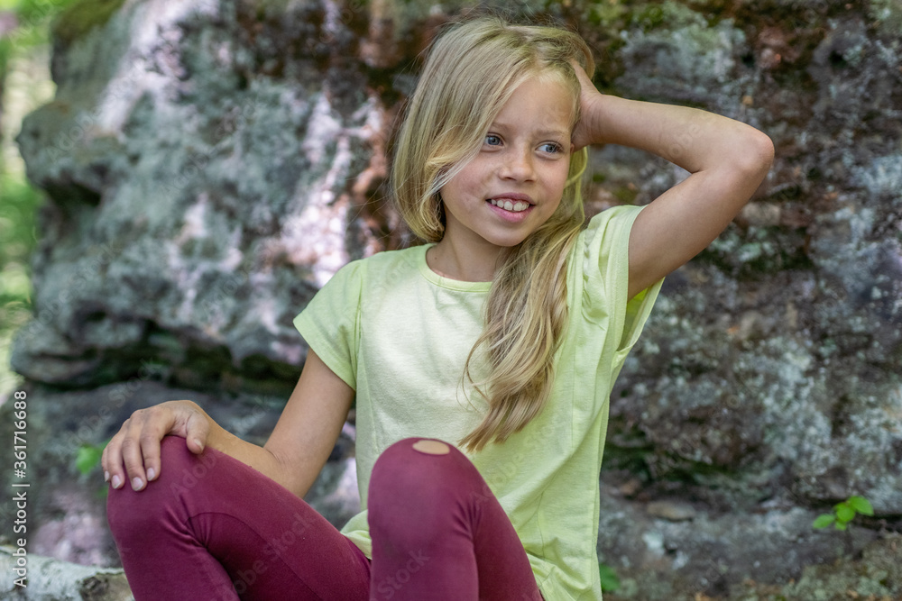 Obraz premium Mädchen beim unbeschwerten Sport und turnerischer Bewegen, wie Akrobatik in der Freizeit, im Wald und in der Natur. Sie trägt legere Kleidung, Shirt und Leggins.