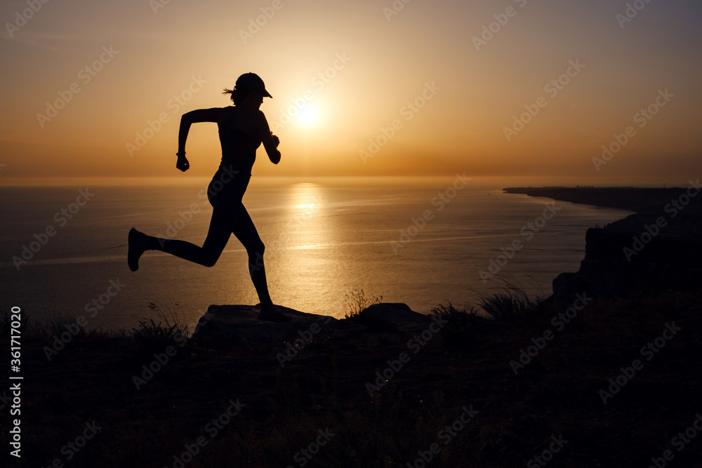 Side view of fitness woman running on a road by the sea. Side view of fitness woman running on a road by the sea.