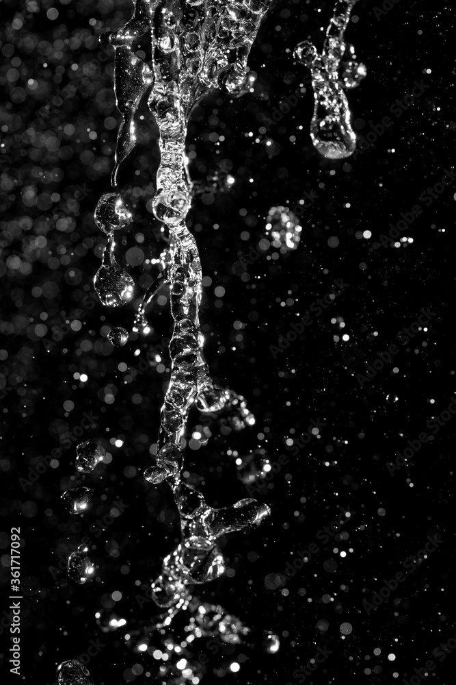 Fototapeta premium water jet with splashes and highlights on a black background