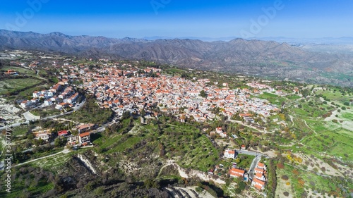 Aerial bird eye view of famous landmark tourist destination valley Pano Lefkara village, Larnaca, Cyprus. Ceramic tiled house roofs, greek orthodox church at south of Troodos hills, Kionia, from above photo