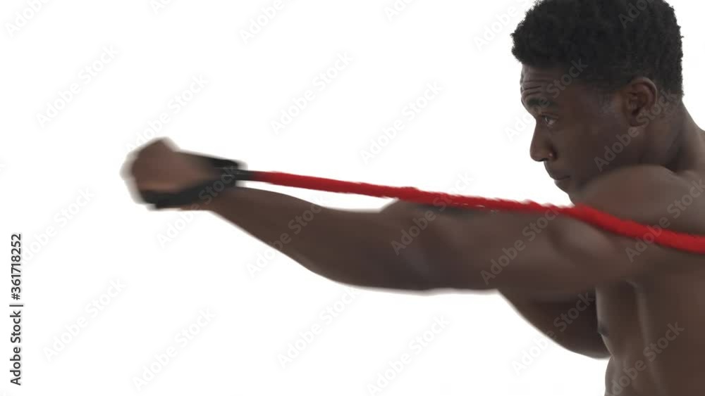 Side view of a highly concentrated African fighter practicing punches with resistance band belt. Professional sport concept. Isolated on white background, copy space close-up shot Side view of a highly concentrated African fighter practicing punches with resistance band belt. Professional sport concept. Isolated on white background, copy space close-up shot