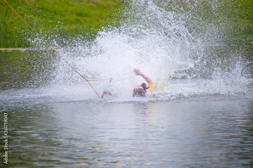 An athlete on a rope surfing on a turn falls into the water © BlackGrizzli