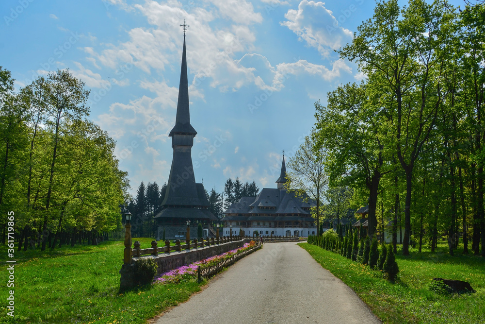 Sapanta Peri Monastery, Maramures, Romania, Europe, spring 2018. Traditional wooden church with the tallest bell tower in the world. Maximum height of 78 meters. Surrounded by vegetation.
