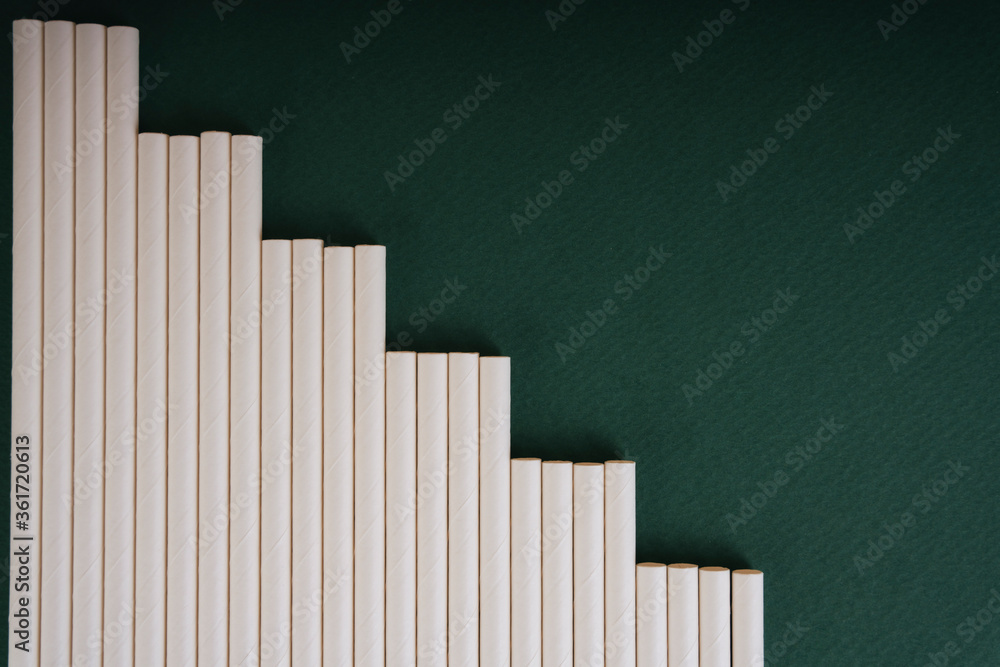 Fototapeta premium Top view - White straw over dark green background. Copy space.