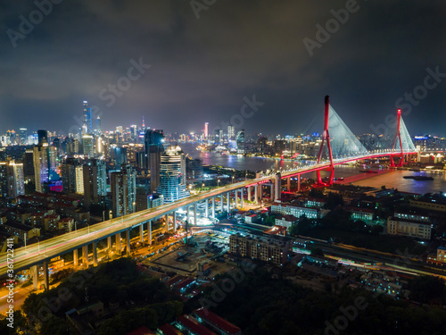 Aerial view of Shanghai cityscape   night-scape. Futuristic modern city view. Downtown Lujiazui District and Yangpu bridge in the night. Neon light and traffic lights. Drone point of view in sky