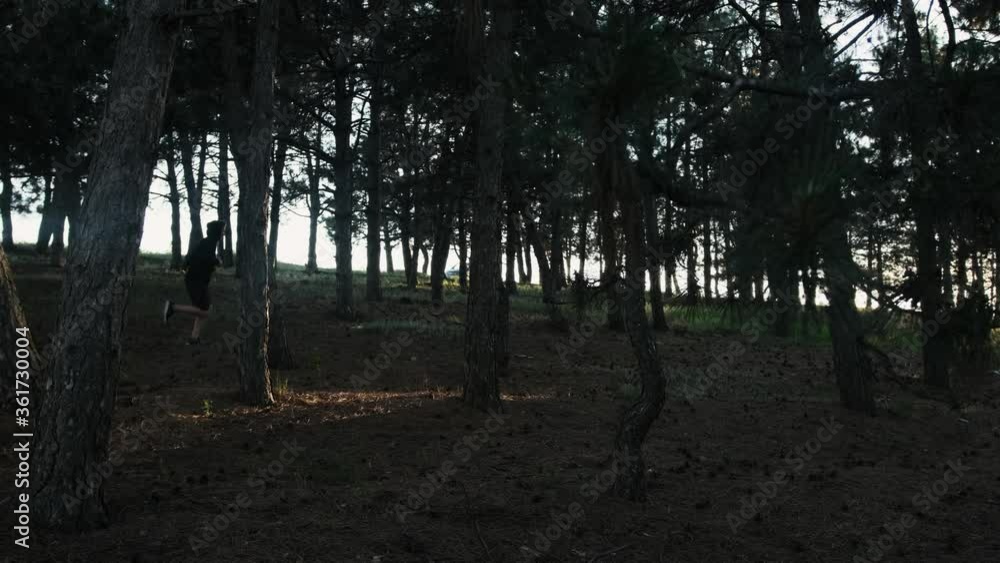 Confident man running in the forest at sunrise/sunset. Healthy lifestyle and digital detox concept. Confident man running in the forest at sunrise/sunset. Healthy lifestyle and digital detox concept.