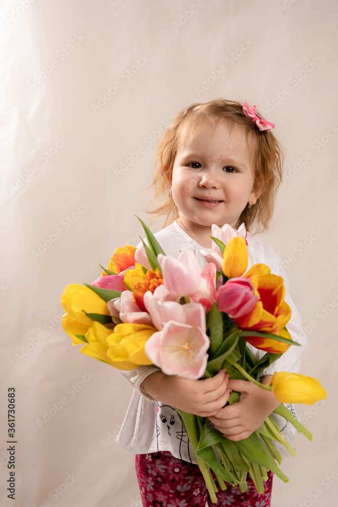 A happy girl with a large bouquet of tulips is smiling because she is very happy A happy girl with a large bouquet of tulips is smiling because she is very happy