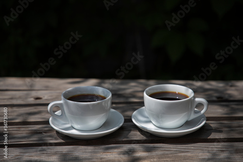 Two cups of coffee filter on a wooden table, side view