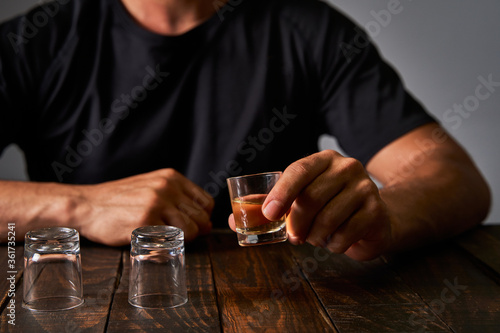 Slika na platnu Man at a bar drinking alcohol in shot glasses