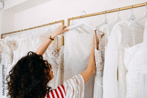 Consultant at a wedding showroom showing new bridal gown collection. photo