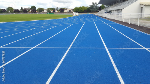Athletics running blue track white line in a sports stadium
