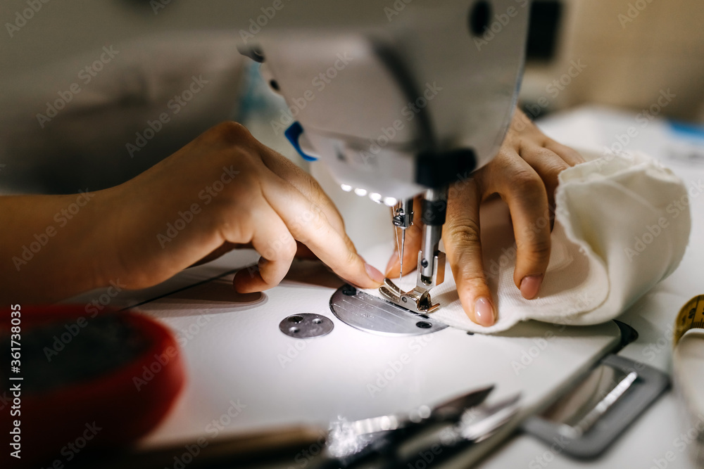 Close up working process of a tailor using a sewing machine, soft focus on needle and fingers. Close up working process of a tailor using a sewing machine, soft focus on needle and fingers.