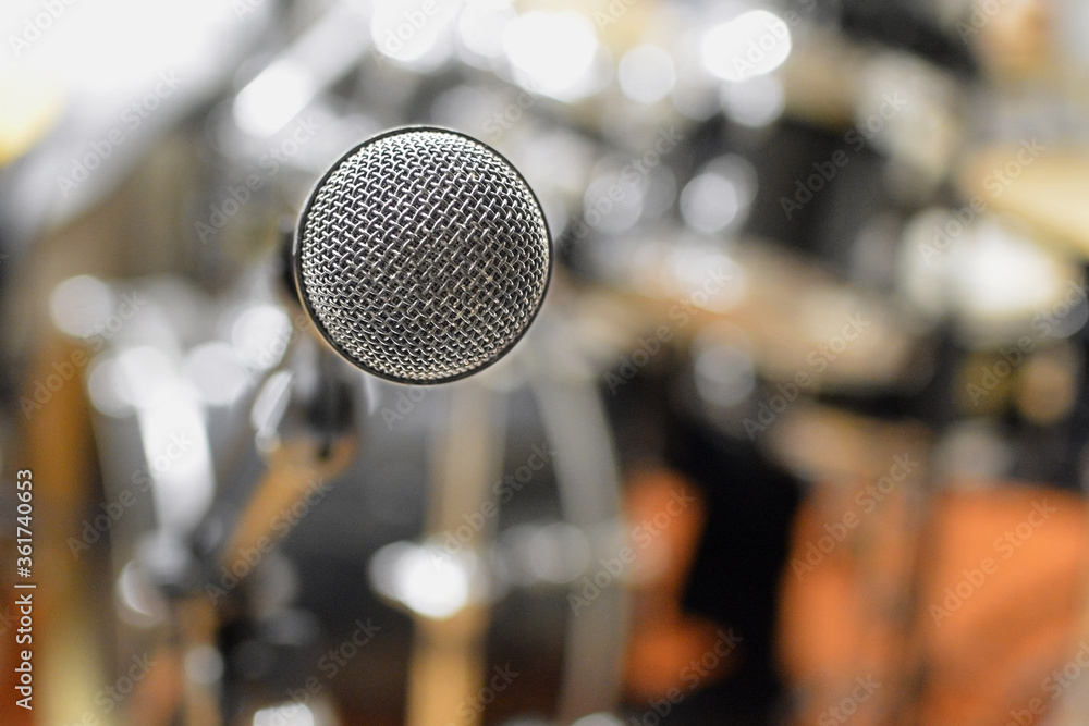 close up of microphone against a background of musical instruments
