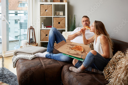 Handsome Man Looking At Girlfriend Eating Pizza