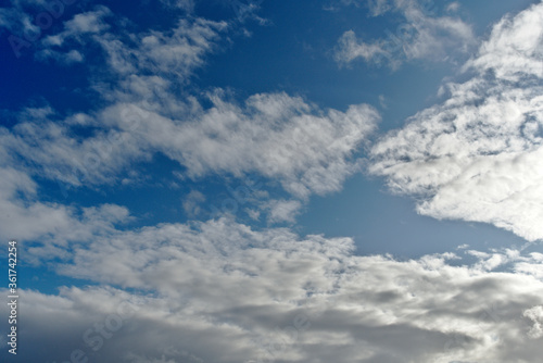 Blue sky with clouds with sun reflections on the right of the image