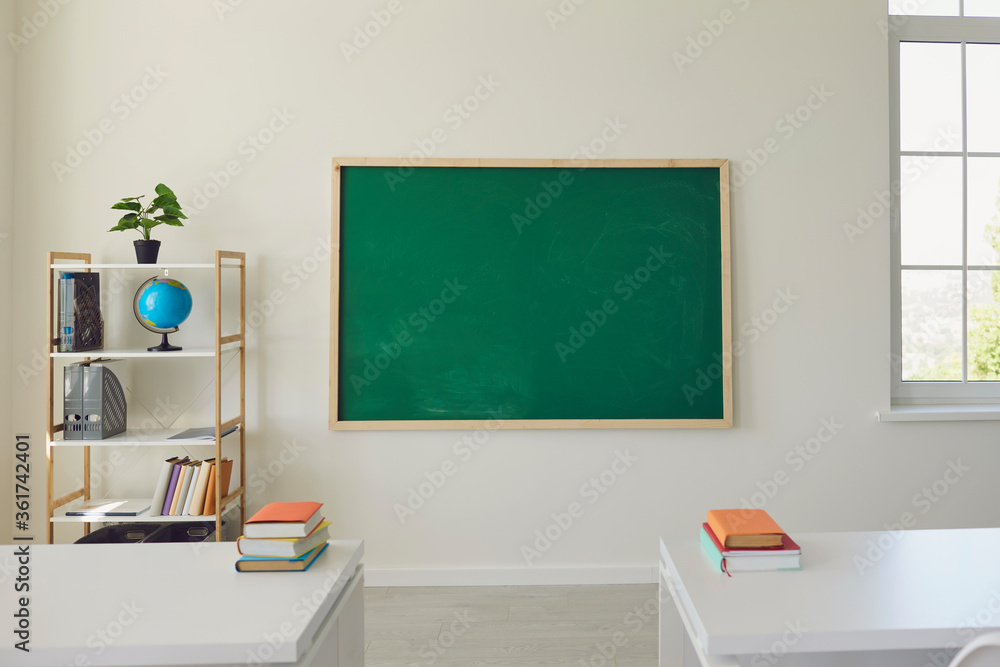 White school classroom interior. Bright lassroom with windows tables chair green board White school classroom interior. Bright lassroom with windows tables chair green board