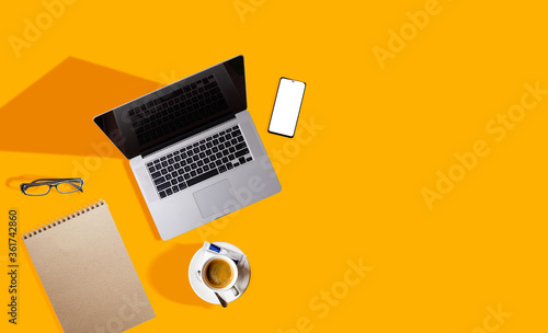 Top view of modern laptop isolated on yellow background. photo