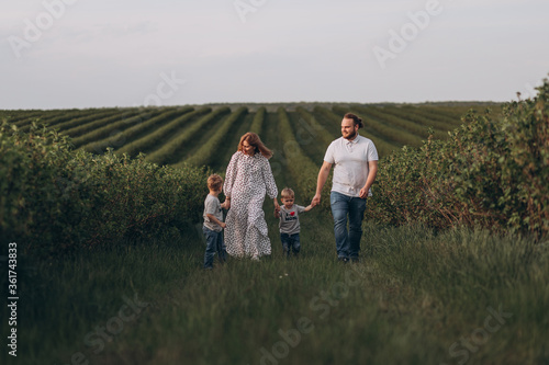Bild auf Leinwand Big young happy family in the field on the nature